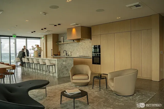 a living room with furniture and a view of kitchen