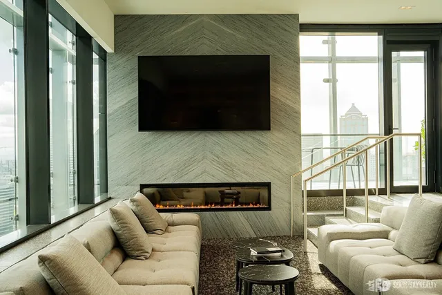 a living room with furniture a flat screen tv and a floor to ceiling window