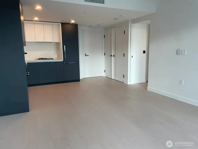 a view of an empty room with a kitchen
