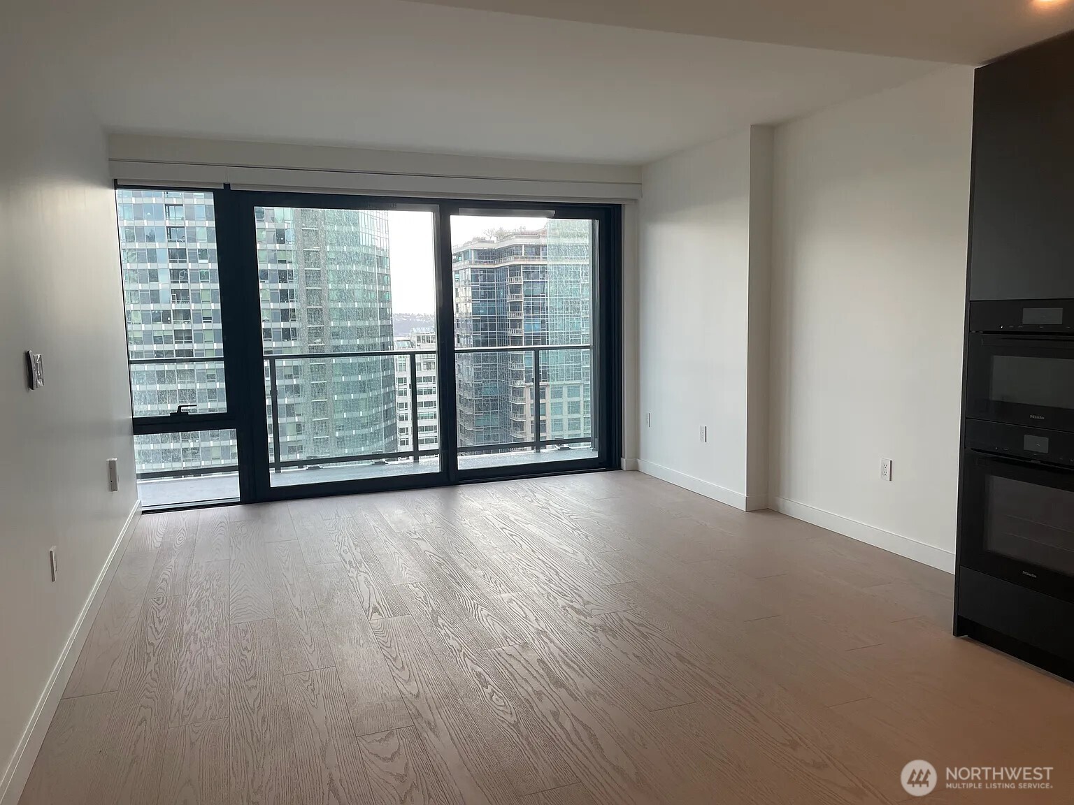 300 Virginia Street, Unit 2210 Seattle, WA 98101 - Photo 9 of 27 an empty room with wooden floor and windows
