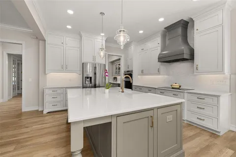 a large white kitchen with a large island