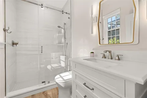 a room with kitchen island stainless steel appliances a sink and wooden floor