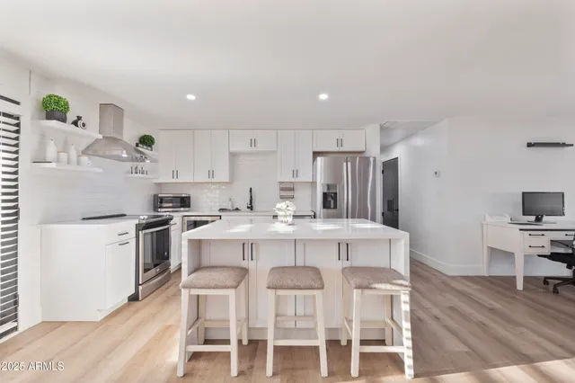 a kitchen with white cabinets and stainless steel appliances