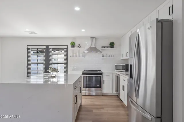 a kitchen with stainless steel appliances a refrigerator sink and stove