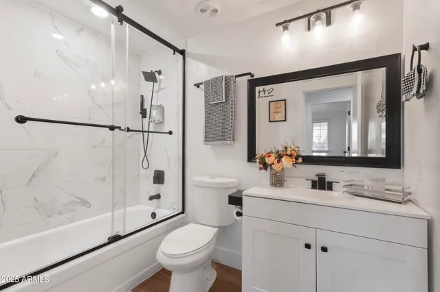 a bathroom with a shower sink vanity mirror and toilet