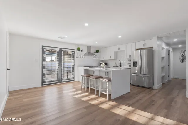 a kitchen with a refrigerator a sink and a stove top oven