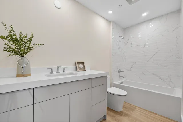 a bathroom with a granite countertop sink a toilet and a bathtub