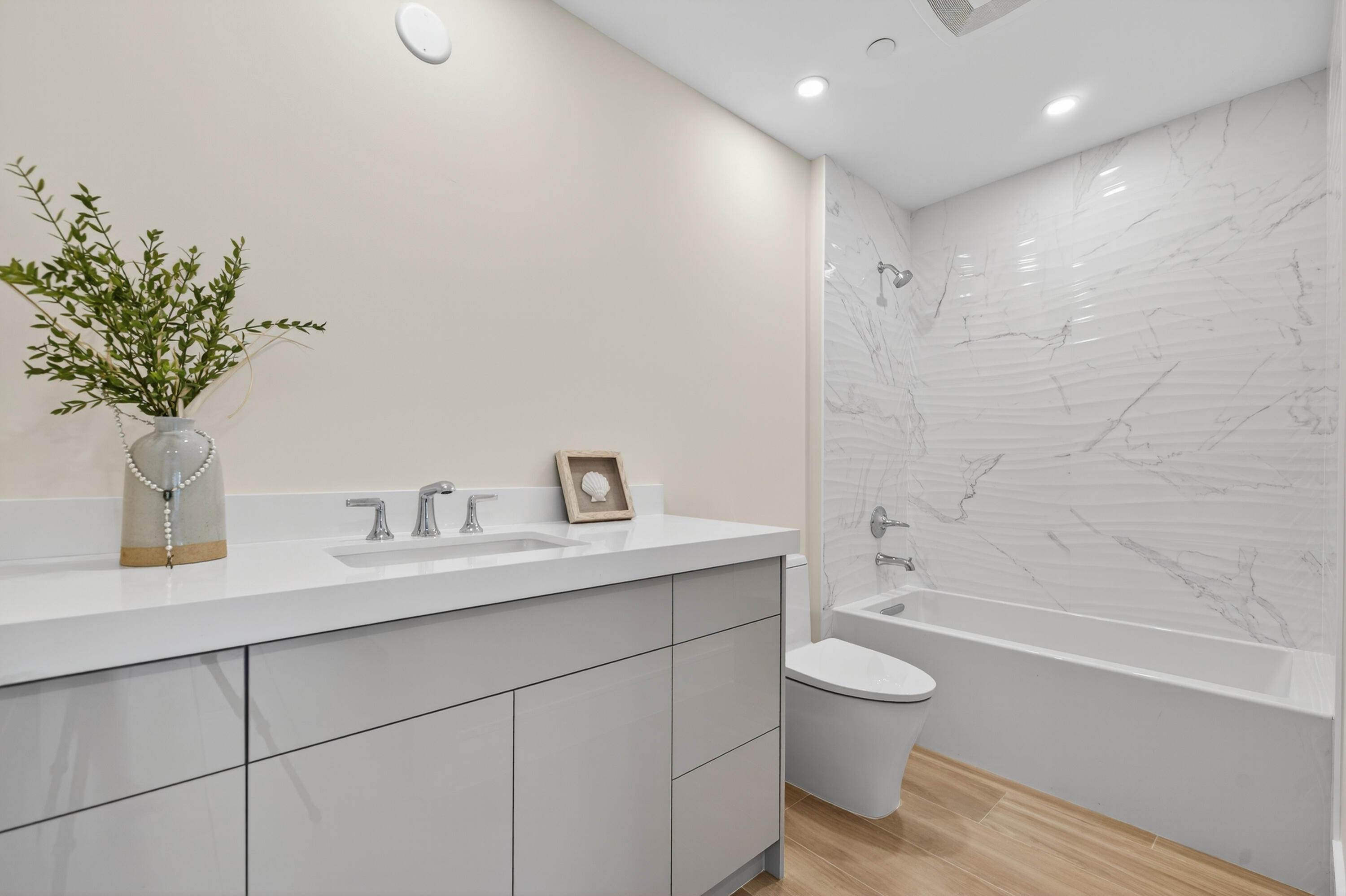 1 South Coastal Way, Unit 303 Jupiter, FL 33477 - Photo 15 of 61 a bathroom with a granite countertop sink a toilet and a bathtub
