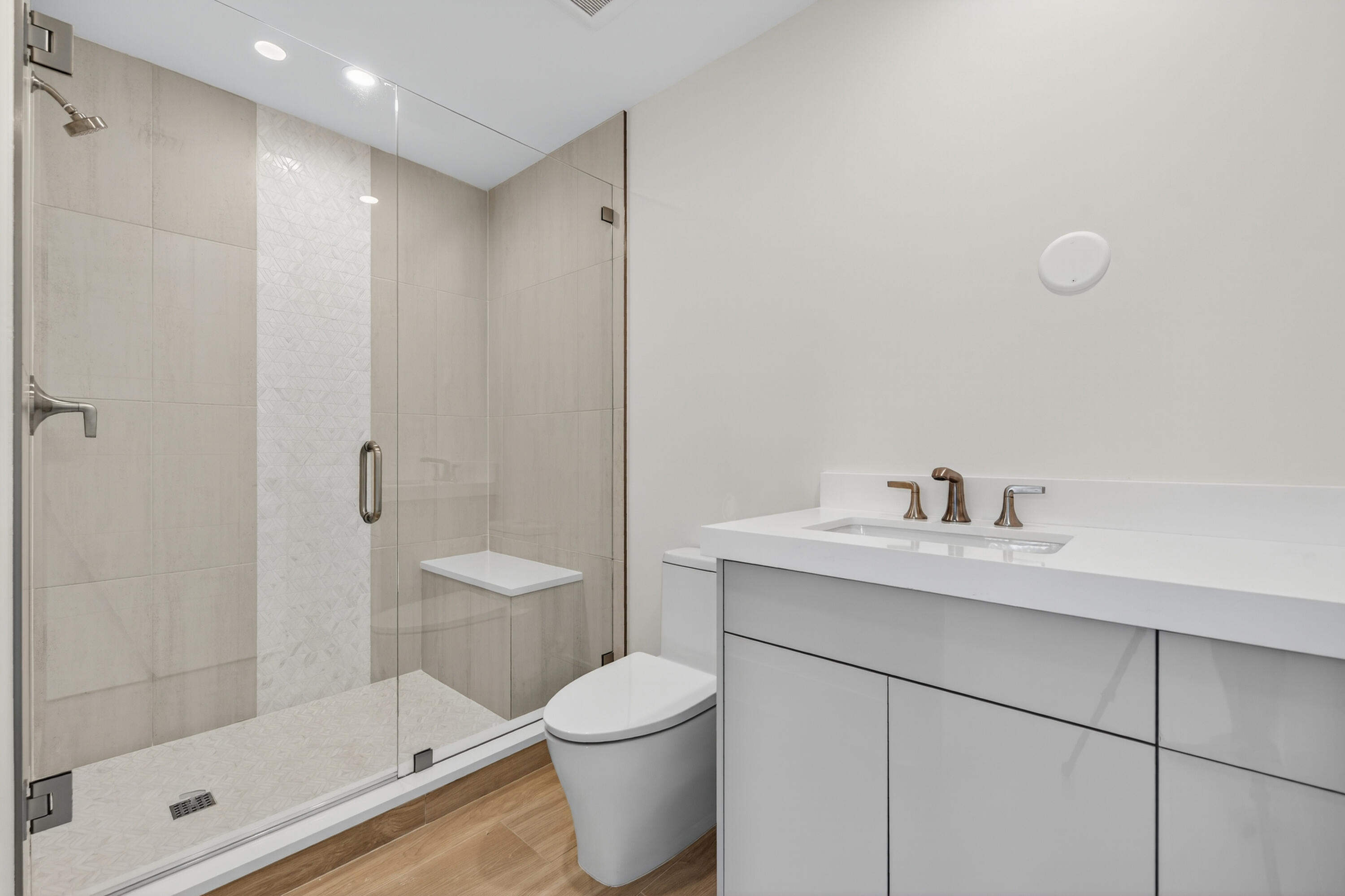 1 South Coastal Way, Unit 303 Jupiter, FL 33477 - Photo 16 of 61 a bathroom with a granite countertop sink a toilet and shower