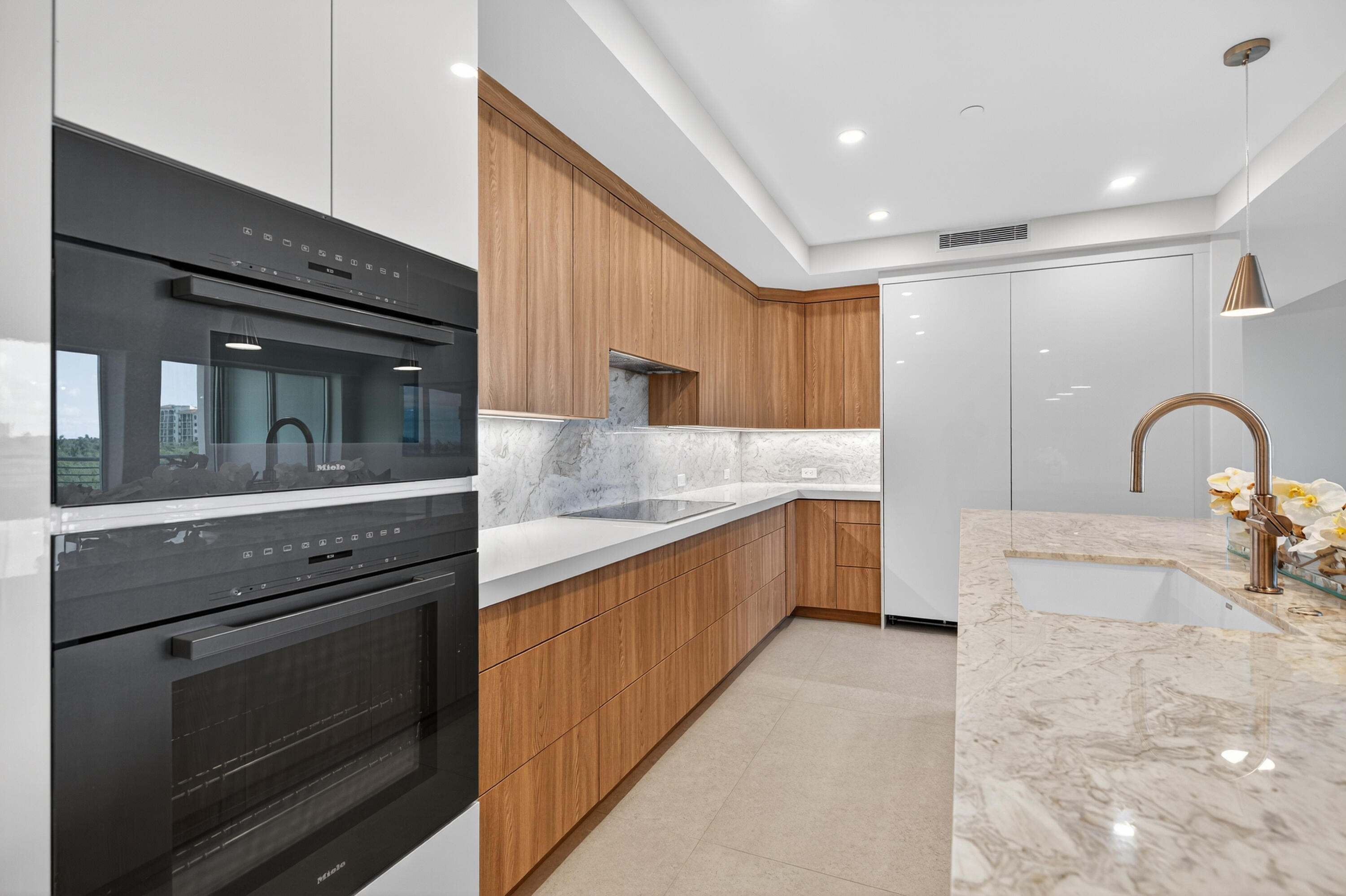 1 South Coastal Way, Unit 303 Jupiter, FL 33477 - Photo 5 of 61 a kitchen with granite countertop a stove and a sink