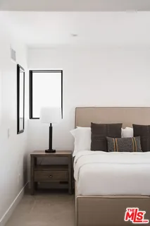 a bedroom with a bed and a large window