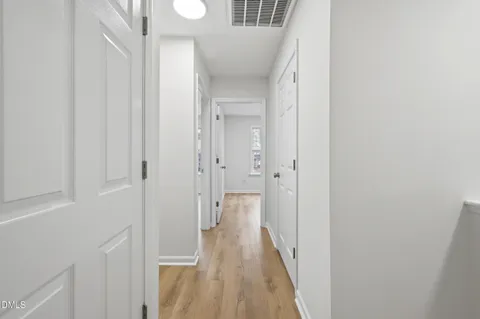 a view of a hallway with wooden floor