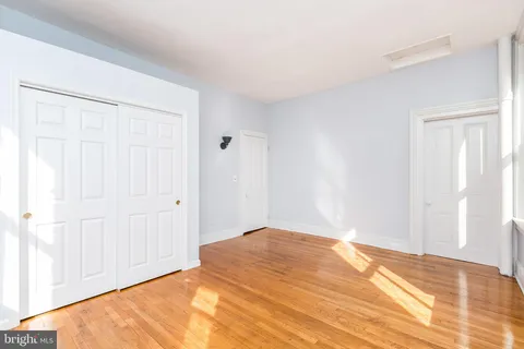 a view of empty room with wooden floor