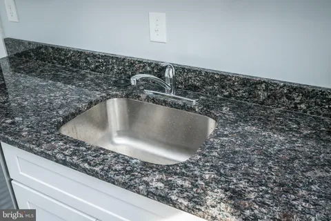 a spacious bathroom with a granite countertop sink a mirror and shower