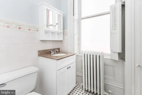 a bathroom with a granite countertop sink a toilet and bathtub