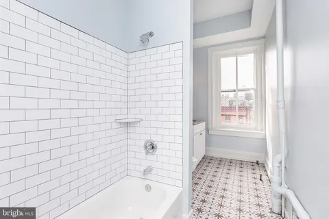 a bathroom with a granite countertop sink toilet mirror vanity and a shower