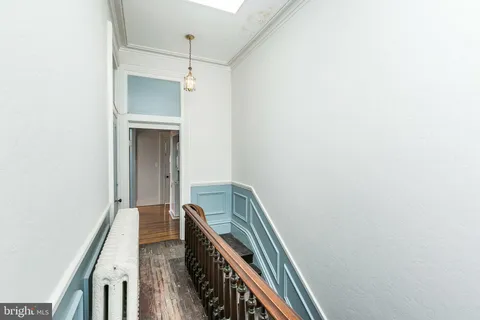 a view of a hallway with wooden floor and entryway