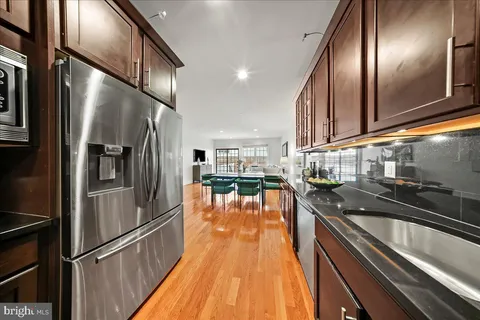 a kitchen with granite countertop stainless steel appliances and wooden floor