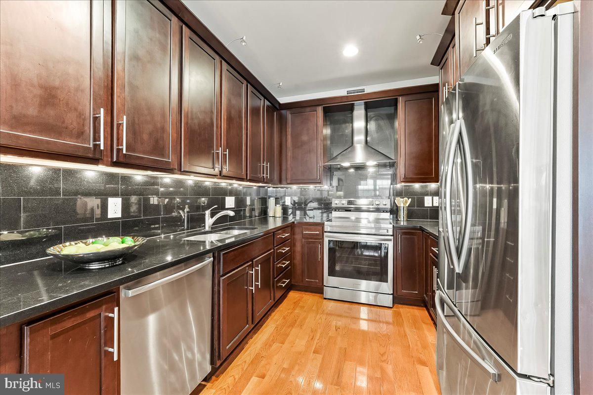 677 North 15th Street Philadelphia, PA 19130 - Photo 14 of 52 a kitchen with stainless steel appliances granite countertop a refrigerator a sink and a stove