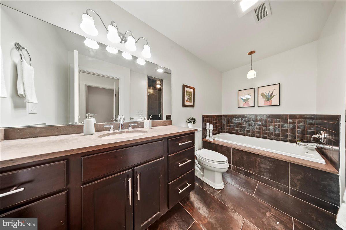 677 North 15th Street Philadelphia, PA 19130 - Photo 34 of 52 a bathroom with a toilet a sink and mirror