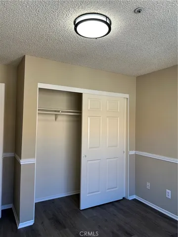an empty room with wooden floor and closet