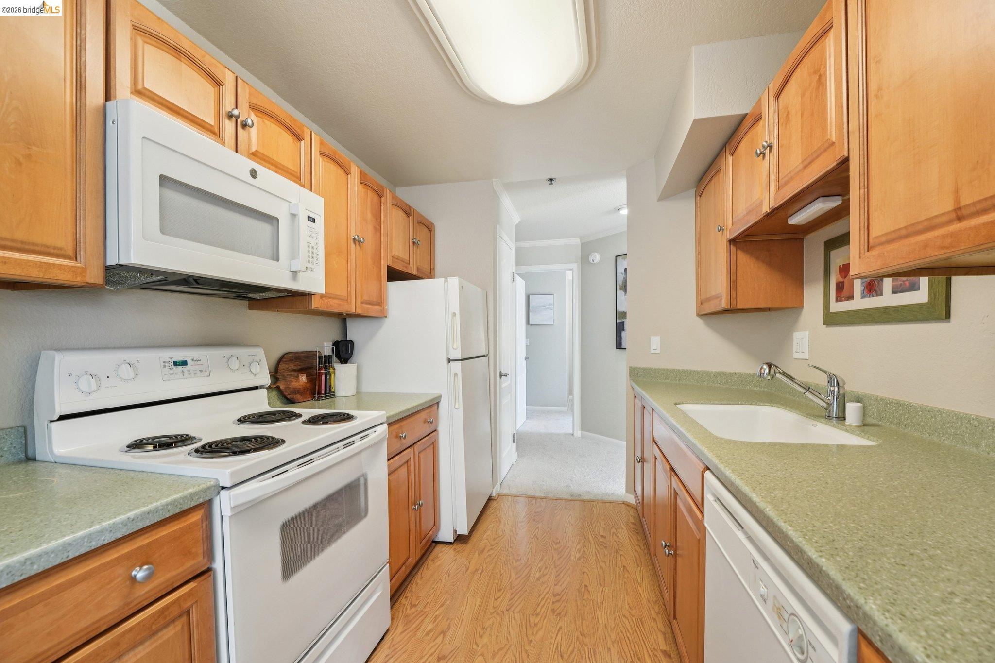 535 Pierce Street, Unit 3216 Albany, CA 94706 - Photo 19 of 47 Kitchen featuring white appliances, light wood-style floors, light countertops, and crown molding