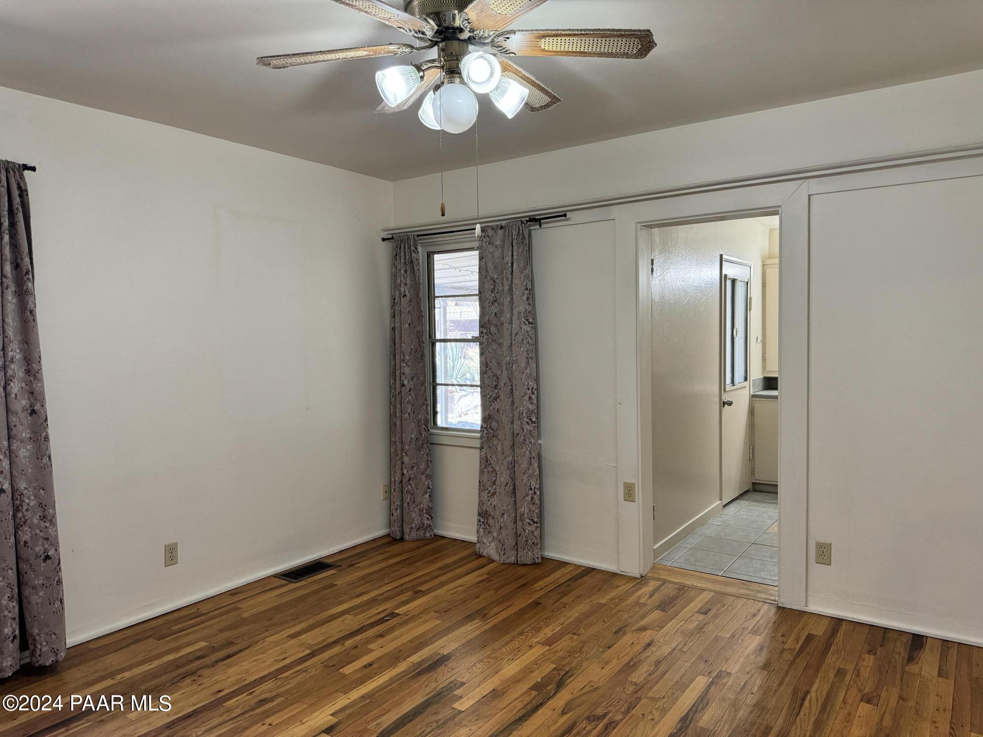 201 Robinson Drive Prescott, AZ 86303 - Photo 12 of 52 an empty room with wooden floor fan and windows