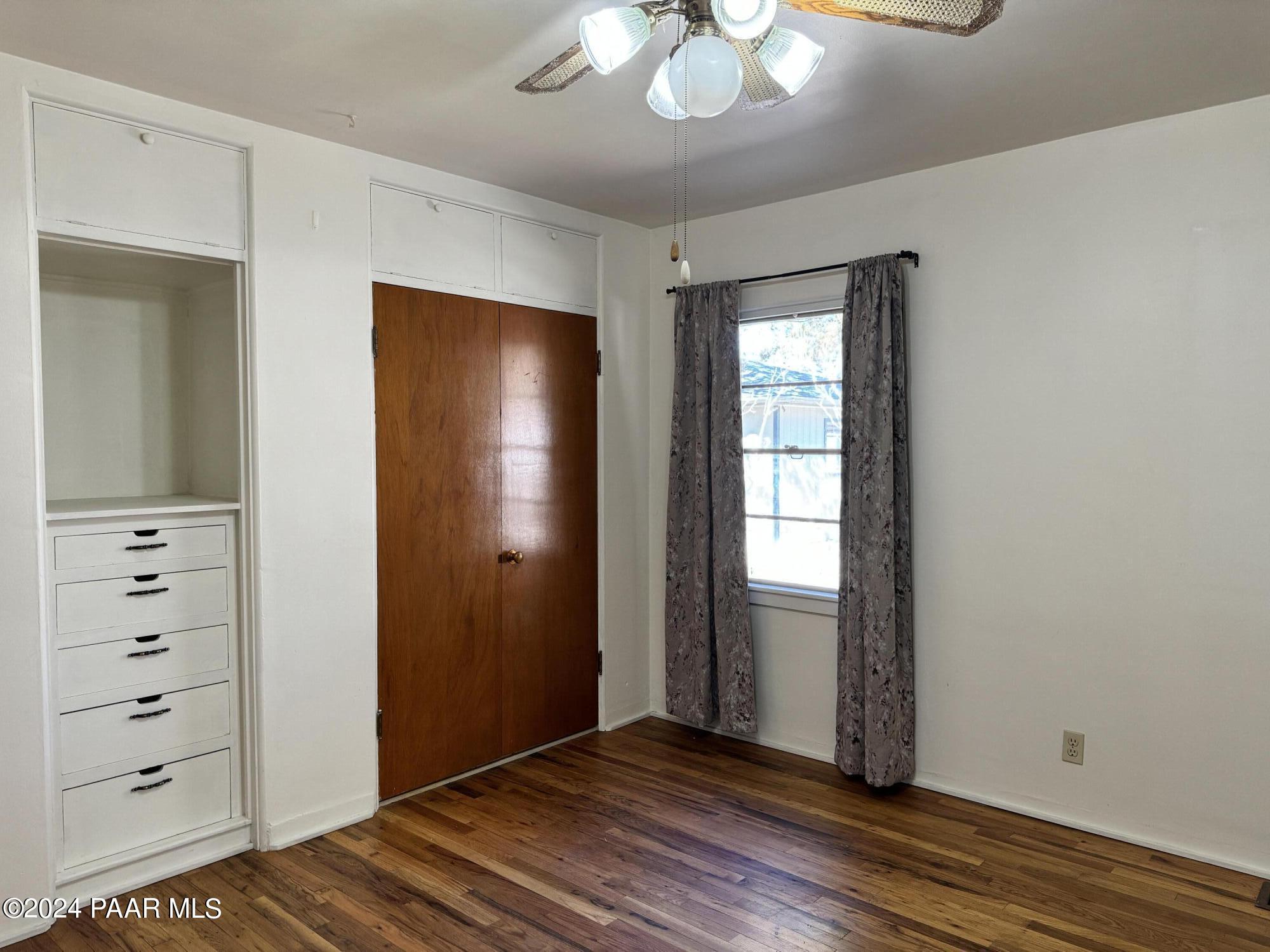 201 Robinson Drive Prescott, AZ 86303 - Photo 15 of 52 an empty room with wooden floor cabinet and windows