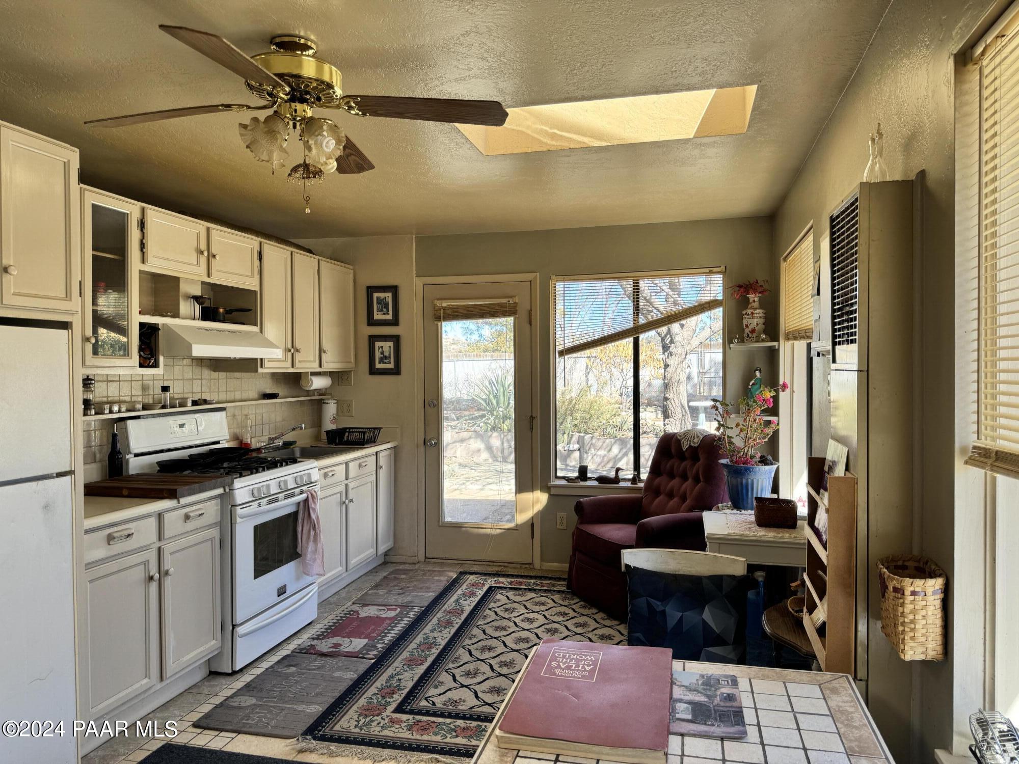 201 Robinson Drive Prescott, AZ 86303 - Photo 34 of 52 a open kitchen with stainless steel appliances granite countertop a stove a sink dishwasher a dining table and chairs with wooden floor