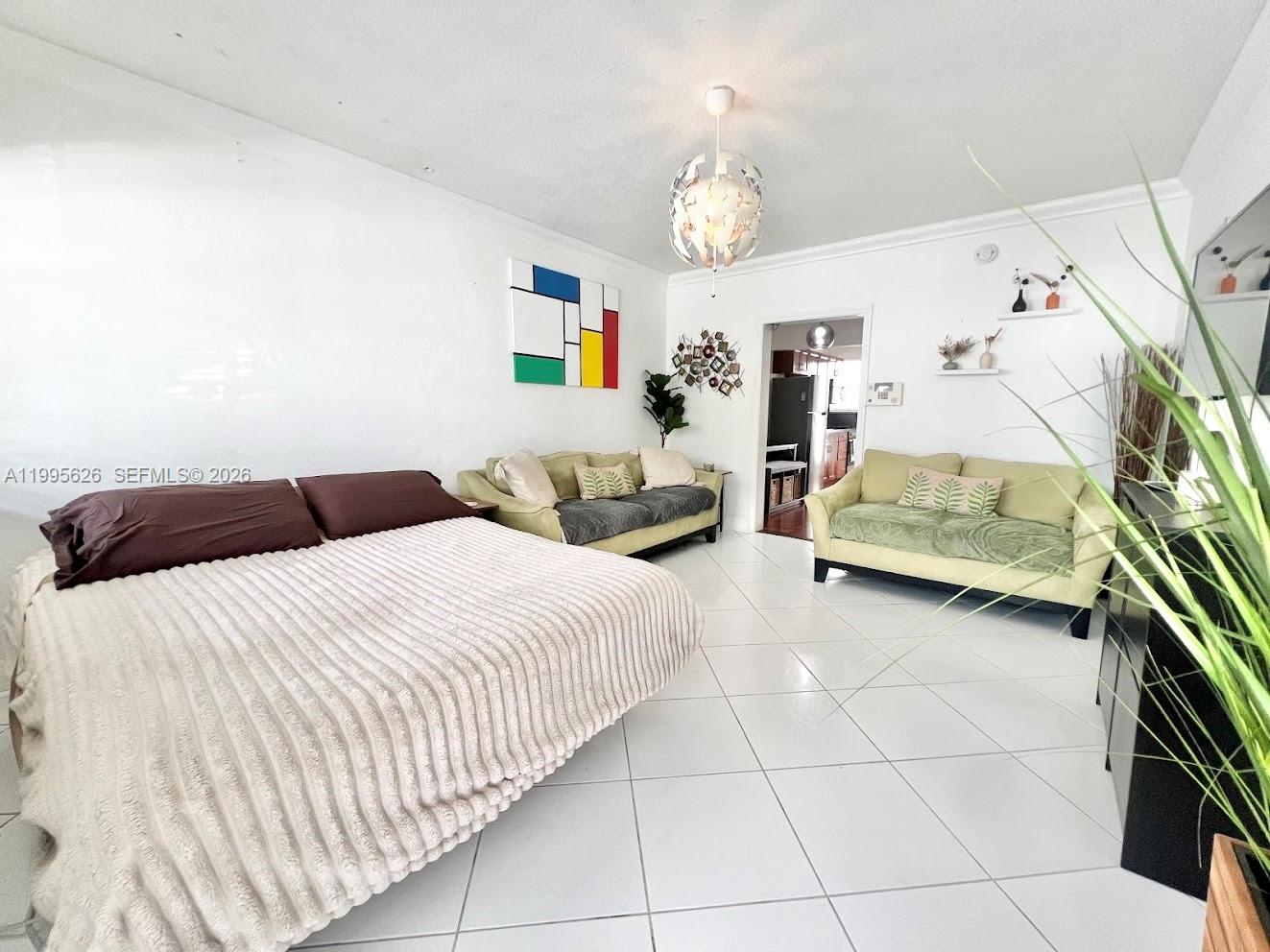 330 74th Street, Unit 5 Miami Beach, FL 33141 - Photo 7 of 19 a bedroom with a bed and a chandelier