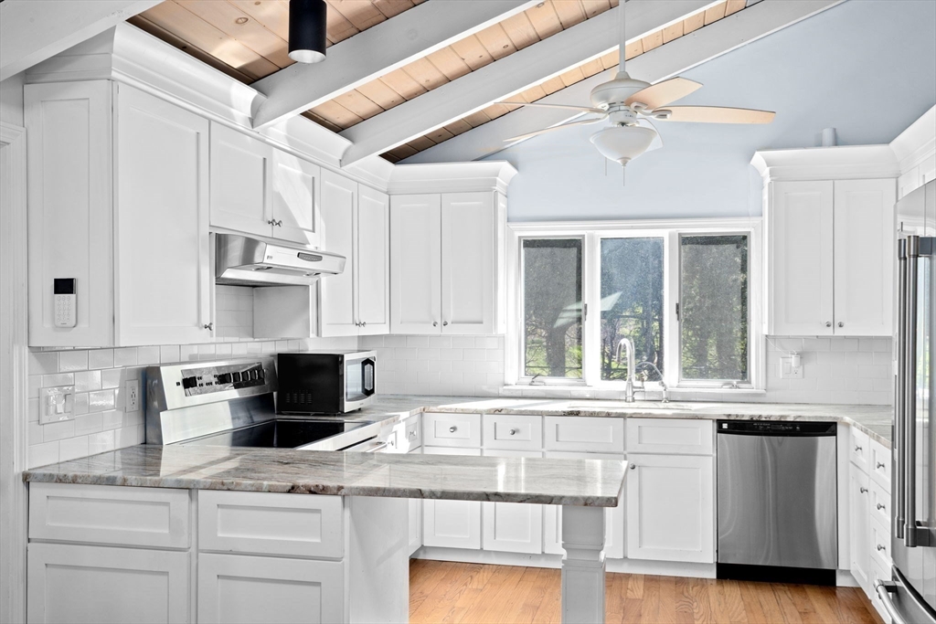 a kitchen with stainless steel appliances granite countertop a sink and cabinets with wooden floor