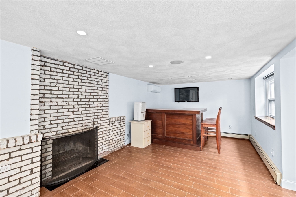 27 Everett Street Norfolk, MA 02056 - Photo 19 of 37 a living room with furniture a fireplace and a flat screen tv