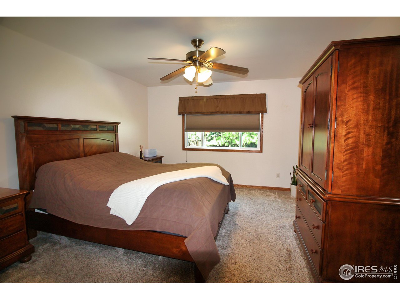 14363 Dakota Road Sterling, CO 80751 - Photo 11 of 40 a bedroom with a bed and a chandelier