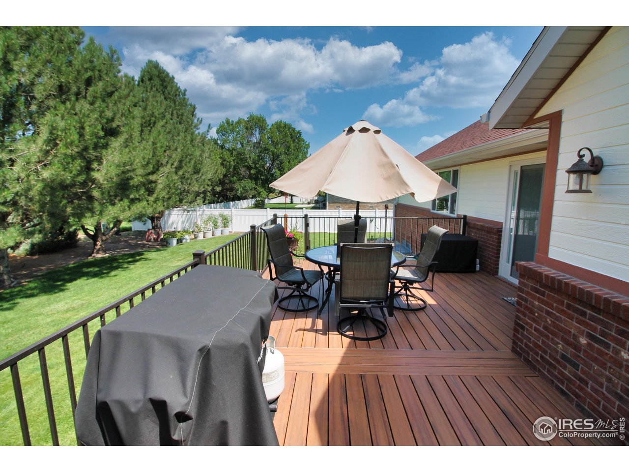 14363 Dakota Road Sterling, CO 80751 - Photo 9 of 40 a view of a patio with table and chairs under an umbrella with wooden floor
