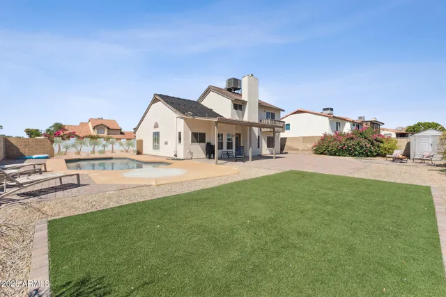 a view of a house with a big yard and a large tree