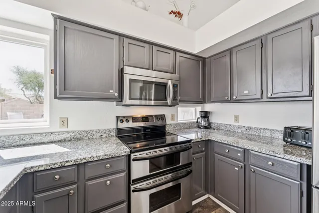 a kitchen with granite countertop cabinets stainless steel appliances and a sink