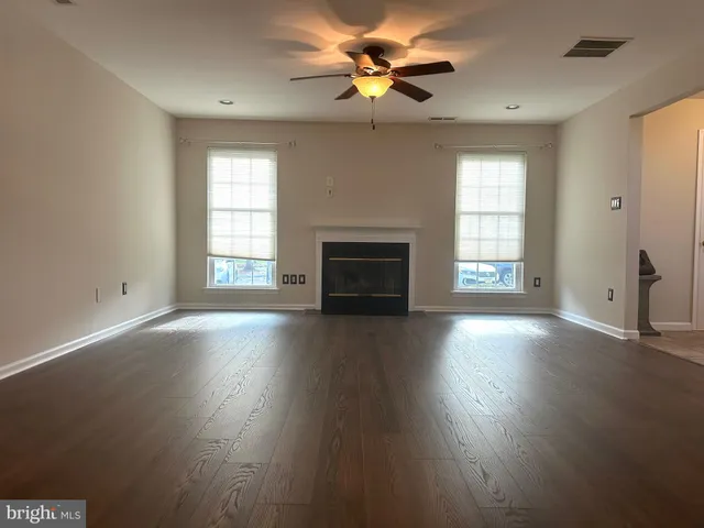 a view of an empty room with a fireplace and a window