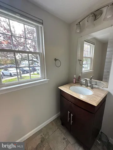 a bathroom with a granite countertop sink a large mirror and a window