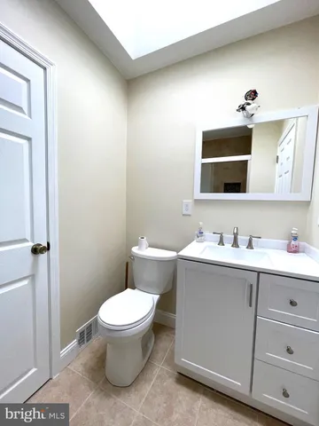 a bathroom with a toilet a sink a mirror and vanity
