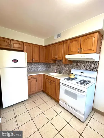 a kitchen with a stove a refrigerator and a sink