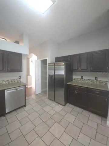 a large kitchen with a stove a sink dishwasher and a refrigerator