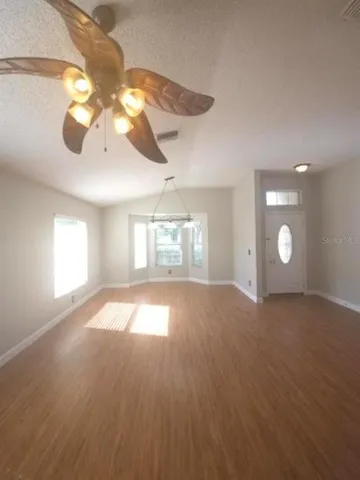 a view of an empty room a window and wooden floor