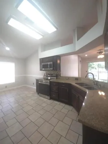 a large kitchen with a sink and cabinets