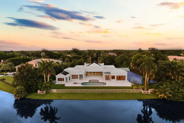 a view of a big house with a big yard and large trees