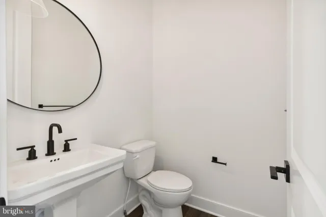 a bathroom with a sink a toilet and a mirror
