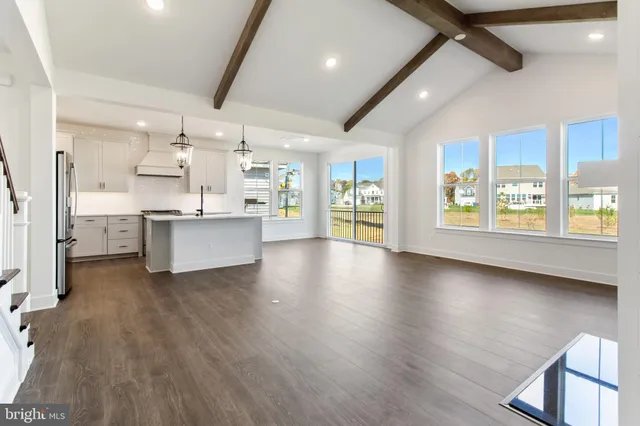 a large kitchen with stainless steel appliances kitchen island a large counter top and a wooden floors