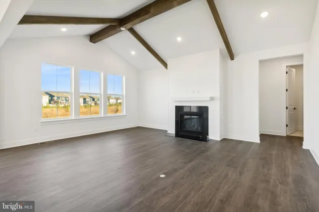 a view of an empty room with a window and fireplace