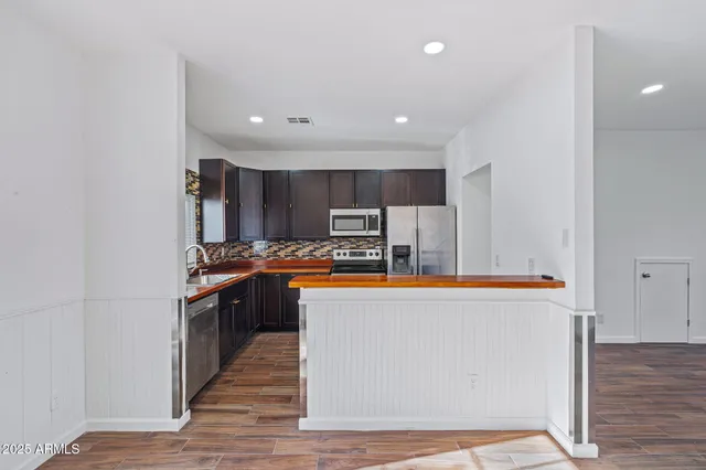 a large kitchen with stainless steel appliances a refrigerator and a stove