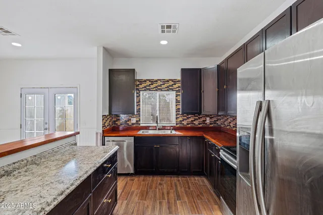 a kitchen with stainless steel appliances granite countertop a refrigerator and a sink