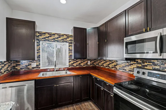 a kitchen with a sink and stainless steel appliances